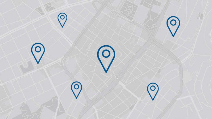 A map with several blue location markers on a light gray background.
