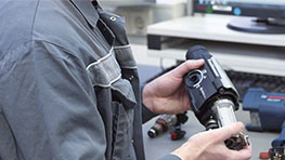 A technician holds a Bosch Professional tool in a workshop.