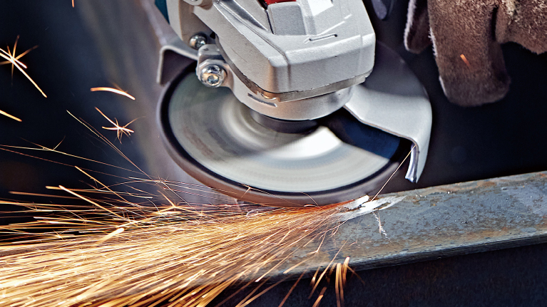 A Bosch Professional angle grinder produces sparks when cutting.
