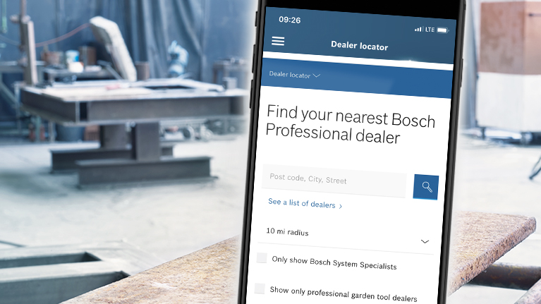 A smartphone displays the Bosch Professional dealer search in a workshop.