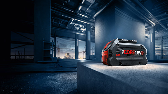 A black Bosch Professional battery on a gray concrete block at a construction site.