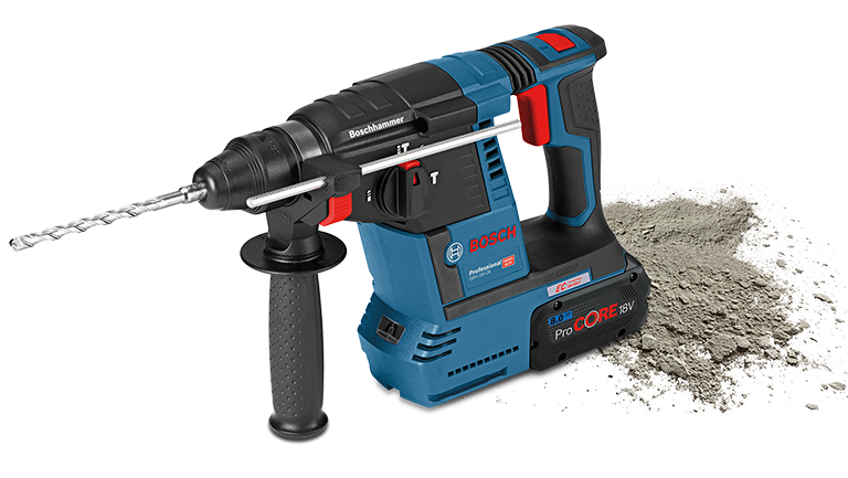 A blue Bosch Professional cordless hammer lies next to gray concrete dust.