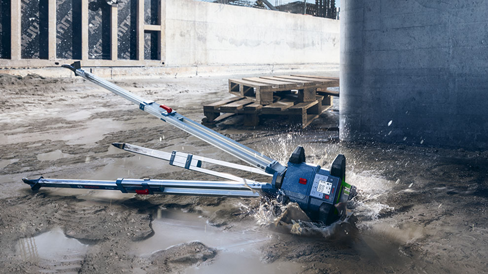 A Bosch Professional tool sprays water on a construction site floor.
