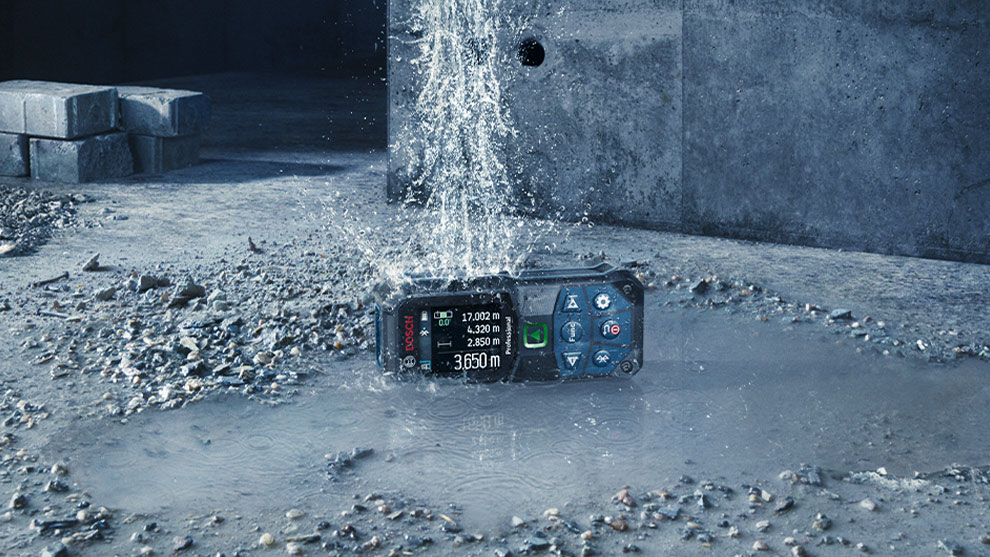 Bosch Professional distance measurer in a puddle on concrete floor.