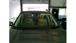 A gray car is parked in a workshop with beige seats.