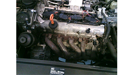 A car engine with metallic parts and an orange oil dipstick.