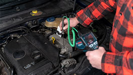 A mechanic is checking the engine with a Bosch Professional diagnostic tool.