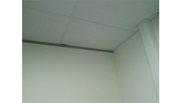 Corner of a room with white walls and ceiling, minimalist and bright.