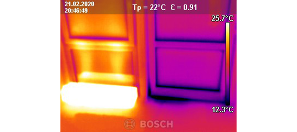 Thermal image of a wall with a bright spot at the bottom, temperature readings.